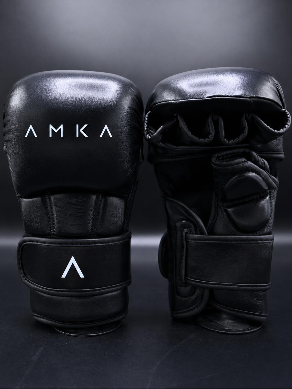Black MMA gloves with 'AMKA' branding on a dark background